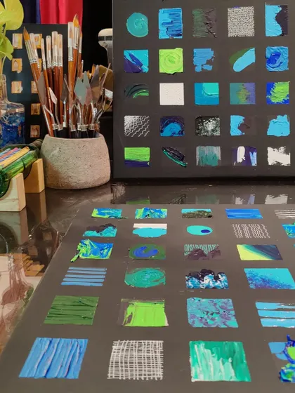 A close-up of the studio table during the creation of the grid paintings, showing the palette knives and brushes used to create the varied textures.