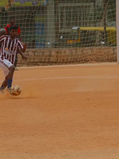 A player on the attack, dribbling towards the opponent's goal during a C-Division match. We encourage creative and confident play.