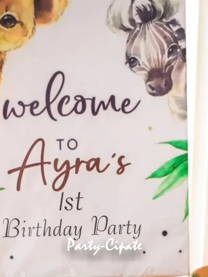 A warm welcome to Ayra's first birthday party. The welcome sign features safari animals and is framed by a colorful balloon arrangement, setting the tone for a fun celebration.