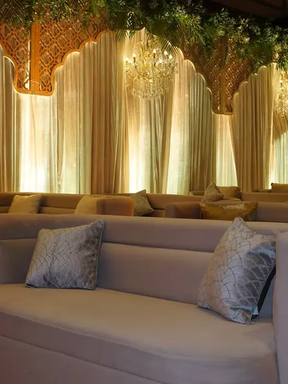 The lounge seating illuminated by the warm glow of chandeliers, creating a cozy and inviting atmosphere for conversations.