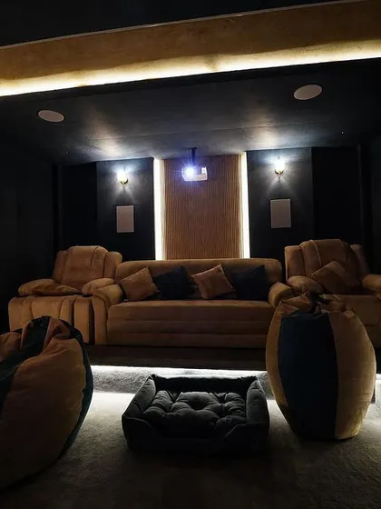 A view from the front of the room, looking back at the tiered seating. The warm, indirect lighting creates a cozy and cinema-like feel.