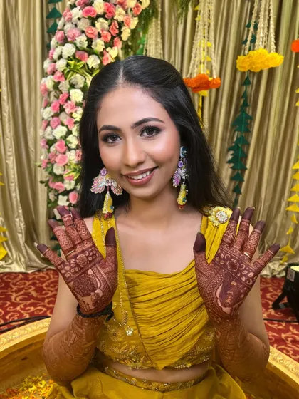 The bride showing off her beautiful henna. The makeup is designed to be long-lasting and comfortable for all the pre-wedding rituals.