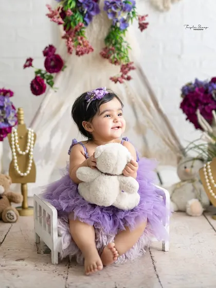 A happy smile and a hug for her teddy bear. I create a comfortable and playful environment so your baby feels relaxed and happy during the session.