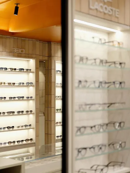 A mirror reflects the store's interior, showcasing the depth and cohesive design created by the repetition of materials and lighting.