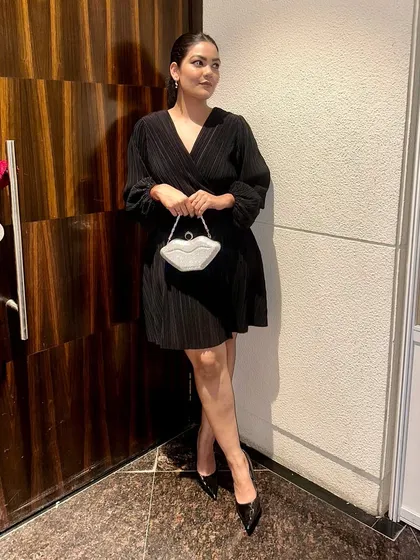 The V-neck and balloon sleeves of this black mini dress make it a flattering and stylish choice for any party.