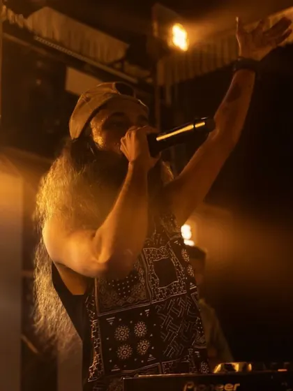 A powerful shot of me on the mic, commanding the stage during a college performance.