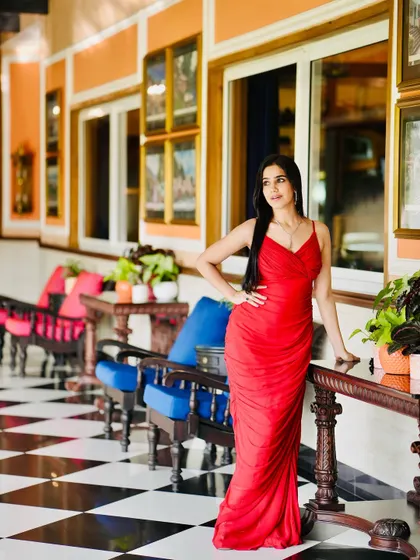 A full-length shot of the red gown in a luxurious hotel corridor, exuding Hollywood glamour.