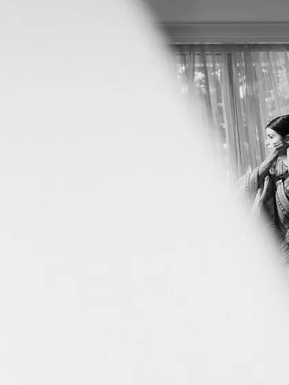 A beautifully composed black and white shot of the bride getting ready, using negative space to create an artistic and pensive mood.