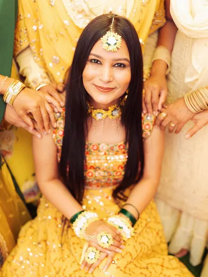 A beautiful portrait of the bride surrounded by the hands of her loved ones. This symbolic shot represents the support and blessings of her family and friends.