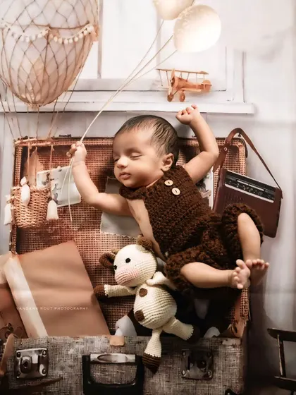 For the little adventurer, this traveler-themed newborn shoot is perfect. I use vintage-style props like a suitcase, a hot air balloon, and a classic radio to create a whimsical setup that sparks the imagination.