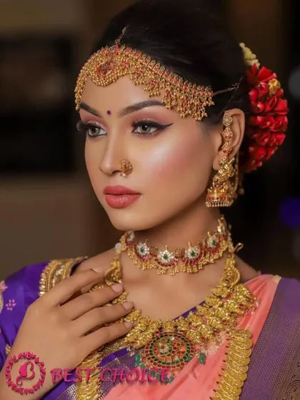 A close-up of the intricate choker and matha patti. The red and green stones add a touch of traditional colour.