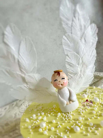 A close-up of the adorable angel topper and her intricate wafer paper wings.