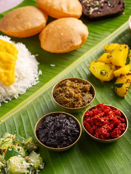 A traditional meal served on a banana leaf, featuring chutneys from Aazol. This styling emphasizes the authentic, regional roots of the products.