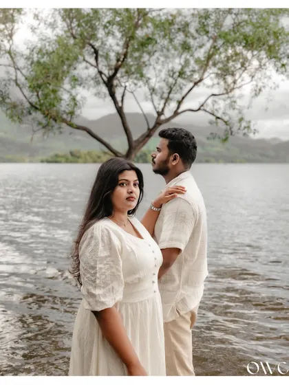 A serene and powerful couple portrait set against the beautiful backdrop of Kerala's backwaters. The calm water and dramatic sky create a cinematic feel for this save-the-date shoot.