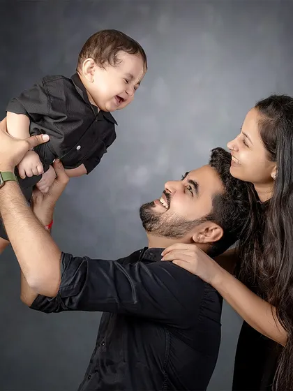 A father lifts his son, and both are filled with laughter. This candid, joyful moment is a perfect example of the authentic family connections I love to capture.