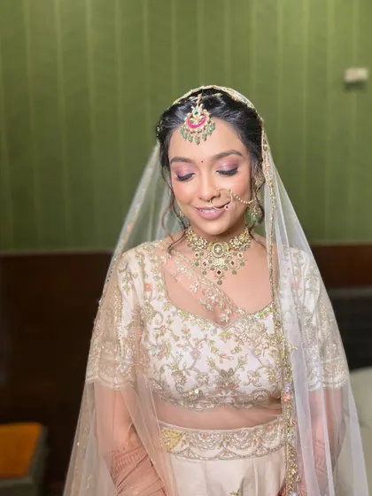 A close-up of the bride with her dupatta, showcasing the delicate eye makeup and flawless skin.