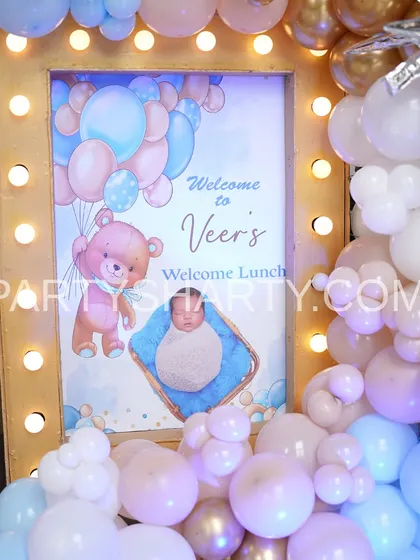 A close-up of a personalized welcome sign for a teddy bear themed lunch, featuring a cute illustration and framed by pastel pink and blue balloons.