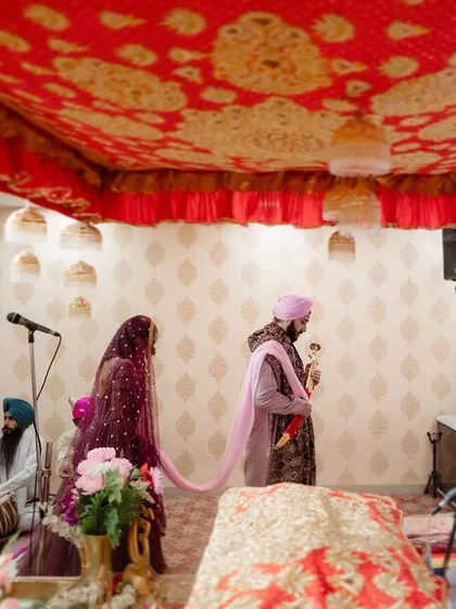 A wide shot of a Sikh wedding ceremony, showing the couple and their families during the rituals. We capture the full scope of your cultural celebrations.