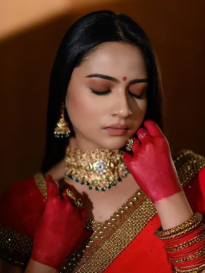 A close-up from our conceptual red saree shoot. The hands stained with red alta add a traditional and symbolic layer to this modern portrait.
