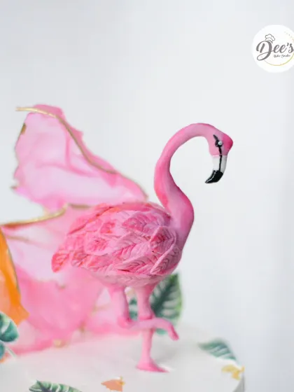 A detailed look at the hand-sculpted flamingo topper, showing the texture on its feathers.