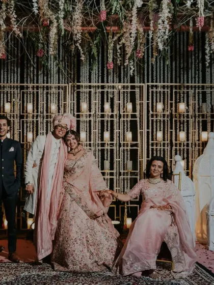 A happy family portrait with the newly married couple and their loved ones against a beautifully decorated backdrop.