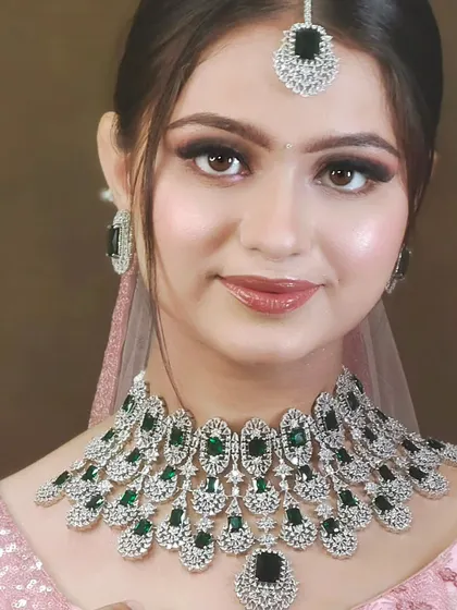 A stunning American Diamond necklace with large green stones. This piece combines the sparkle of diamonds with a pop of traditional color, perfect for a reception.