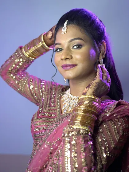 A modern bridal portrait with dramatic purple lighting, highlighting the bride's reception look.
