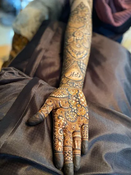 A side view of the bridal mehendi, showing how the pattern wraps around the arm.