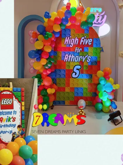 A Minecraft and Lego inspired birthday decoration. The backdrop is designed to look like building blocks, with a colorful balloon arch and a custom Lego-style welcome sign.