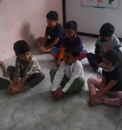Children practice a seated yoga pose. These exercises help improve flexibility and teach children how to follow instructions in a group setting.