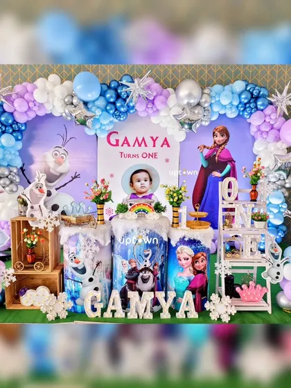 A magical Frozen themed first birthday party for Gamya, complete with character cutouts of Elsa, Anna, and Olaf.