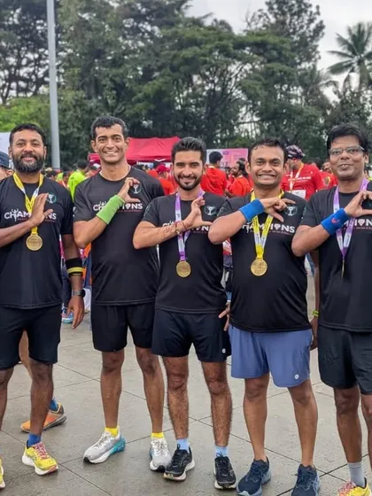 The team showing off their well-earned medals. The matching 'Champions' tees represent the unity and shared goals of our running group.