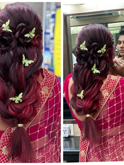 A creative and modern bridal braid with a beautiful mix of red and dark hair. The style is adorned with whimsical butterfly clips, adding a unique touch to a traditional look.