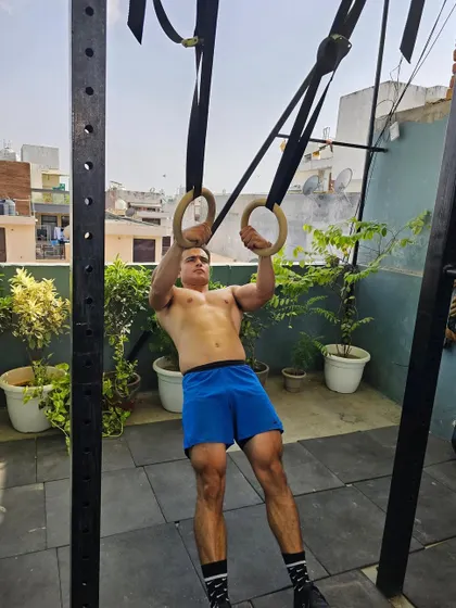 Another candid from a shoot, holding a support position on the gymnastics rings. This exercise builds incredible stability and upper body strength.