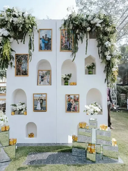 A personalized photo wall we designed, featuring the couple's pictures set within beautifully lit white arches. It’s a wonderful way for guests to engage with the couple's story.