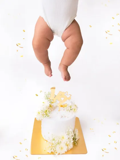 Just the little legs. This creative and funny shot from a half-birthday cake smash session is a playful way to remember this milestone.