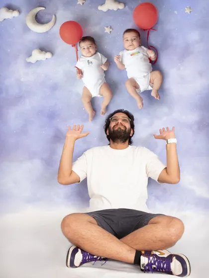 Double the fun with dad! This composite image shows a father looking up in awe at his twin babies floating above him with red balloons.