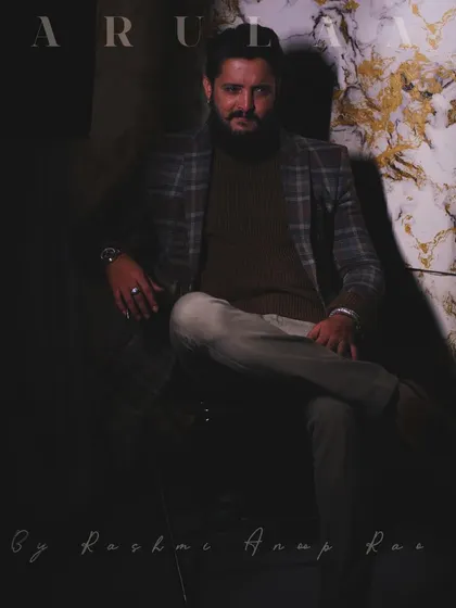A full shot of the dark, moody menswear styling. The entire look, from the custom blazer to the choice of pants and the overall attitude, comes together to create a strong character.