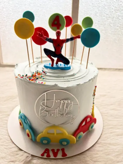 A full view of the Spider-Man and cars cake, perfect for a 4th birthday. The design is bright, playful, and combines two popular themes for kids.