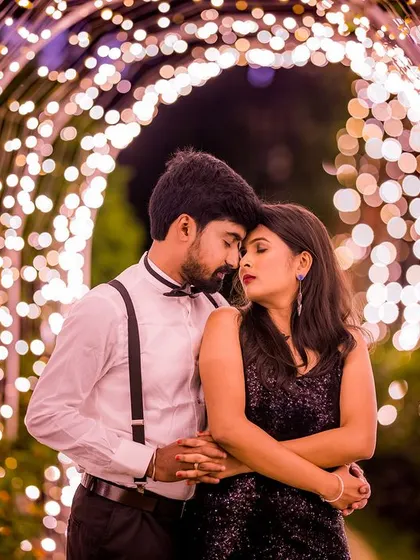 A classic, romantic pose inside the light tunnel. The groom is dressed sharply in a bow tie and suspenders, adding a touch of vintage charm to this beautiful portrait.
