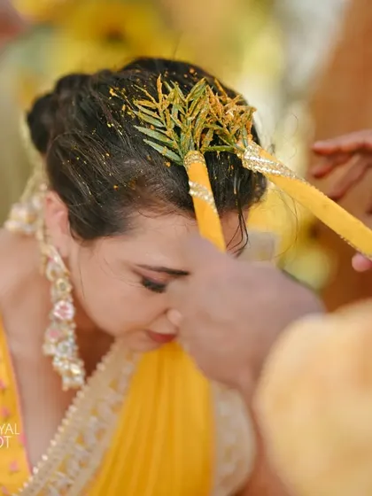 A bride being blessed during a traditional ritual at her sunflower-themed Haldi ceremony in Thailand.