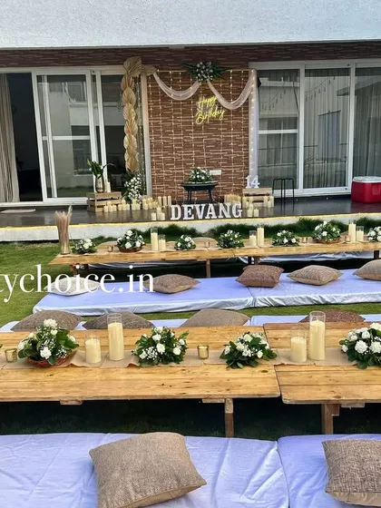 A full view of the beautiful and rustic low-seating dining setup for an intimate outdoor birthday party.