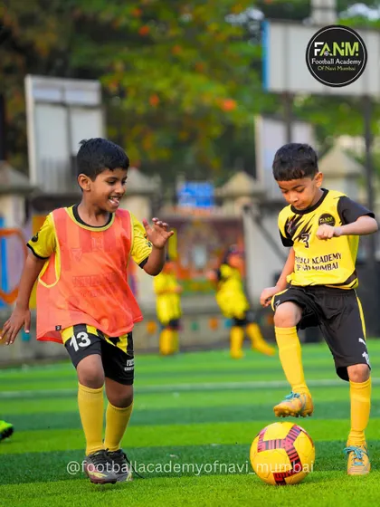 Two young players, one in a bib, challenge for the ball. This shows the fun and competitive nature of our training sessions.