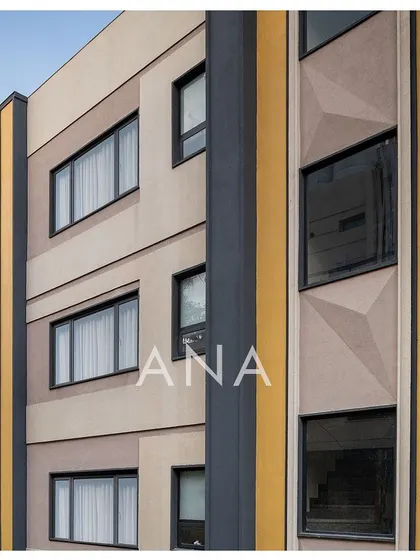 A detailed view of the Yellow Line Apartment's facade, showing the geometric patterns and the vertical yellow band. This was a solution to add visual interest and break the monotony of a flat surface on a narrow plot.