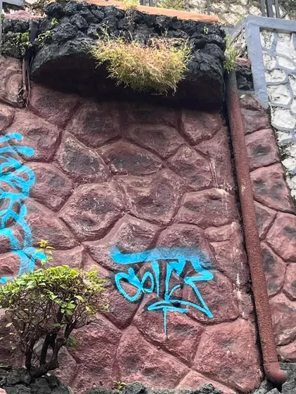 A quick tag on a textured rock wall during a rap cypher event. Art and music, it's all part of the same hip-hop culture.