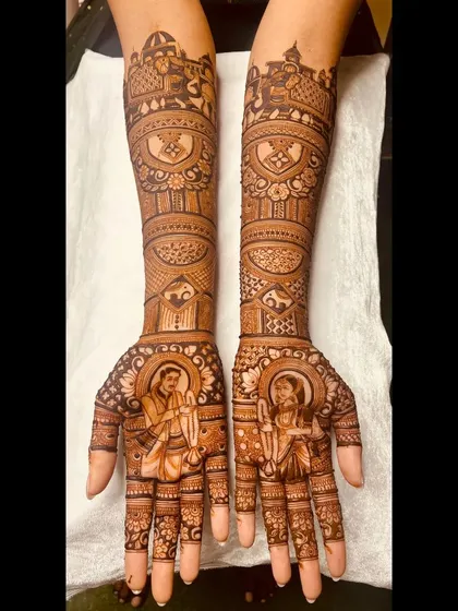 This bridal mehendi features portraits of the bride and groom on the palms, with traditional symbols and architectural domes adorning the arms.