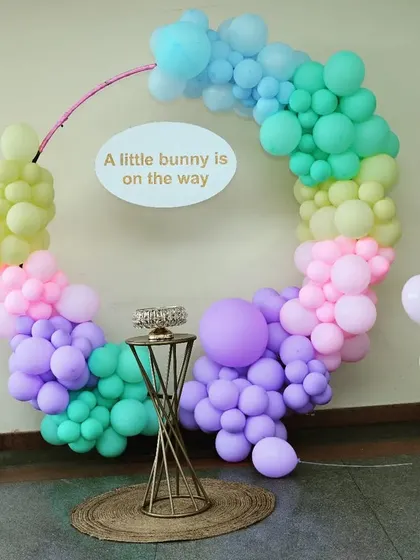 "A little bunny is on the way." This very simple and elegant baby shower decoration uses a pastel rainbow balloon ring to create a sweet and gentle theme.