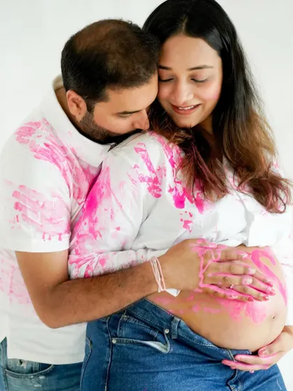 An intimate embrace during the paint reveal, capturing the couple's joy and excitement.