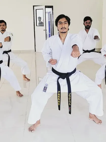 As instructors, we lead by example. We are demonstrating a strong Zenkutsu-Dachi stance with a middle punch, showing the power and focus required in every technique.