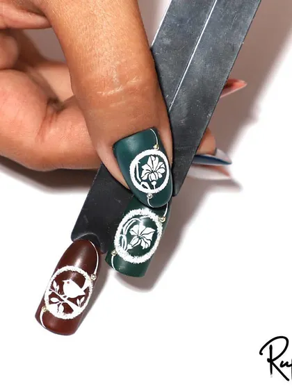 A simple yet elegant design featuring a white floral drawing on a dark green and brown matte base.
